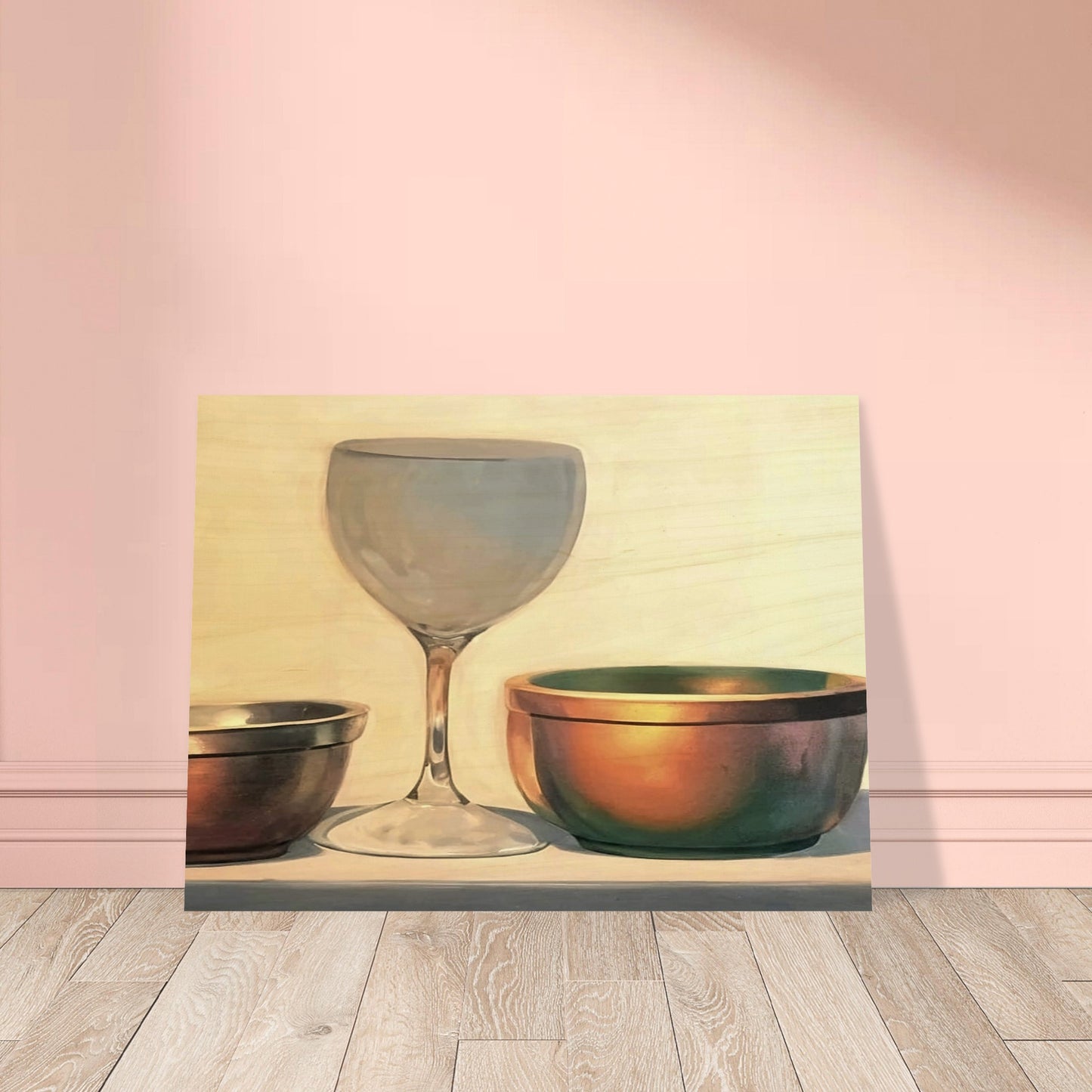A glass chalice and two metallic bowls arranged in soft light, highlighting their reflective surfaces in a subtle, elegant composition.