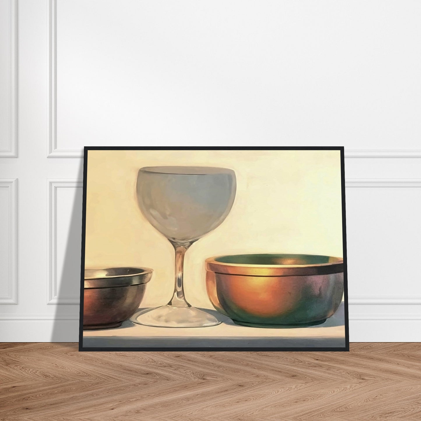 A glass chalice and two metallic bowls arranged in soft light, highlighting their reflective surfaces in a subtle, elegant composition.