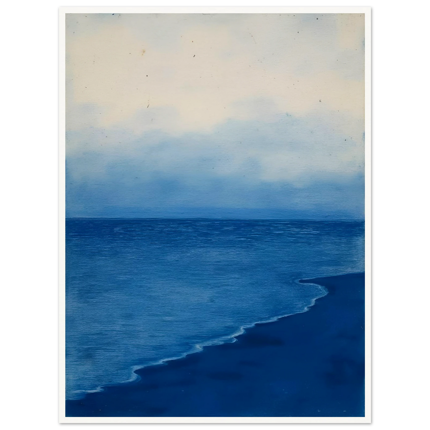 A calm, blue shoreline fades into the horizon under a soft, cloudy sky, evoking peace and solitude.