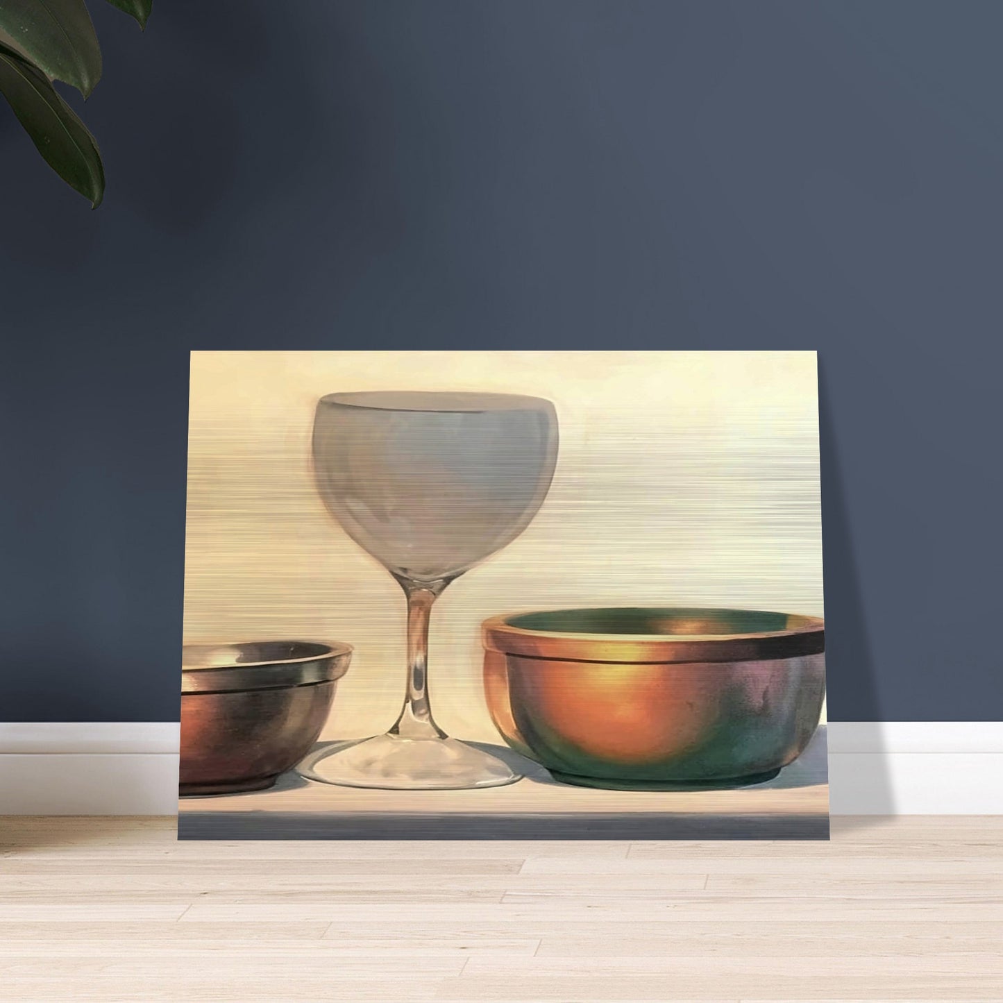 A glass chalice and two metallic bowls arranged in soft light, highlighting their reflective surfaces in a subtle, elegant composition.