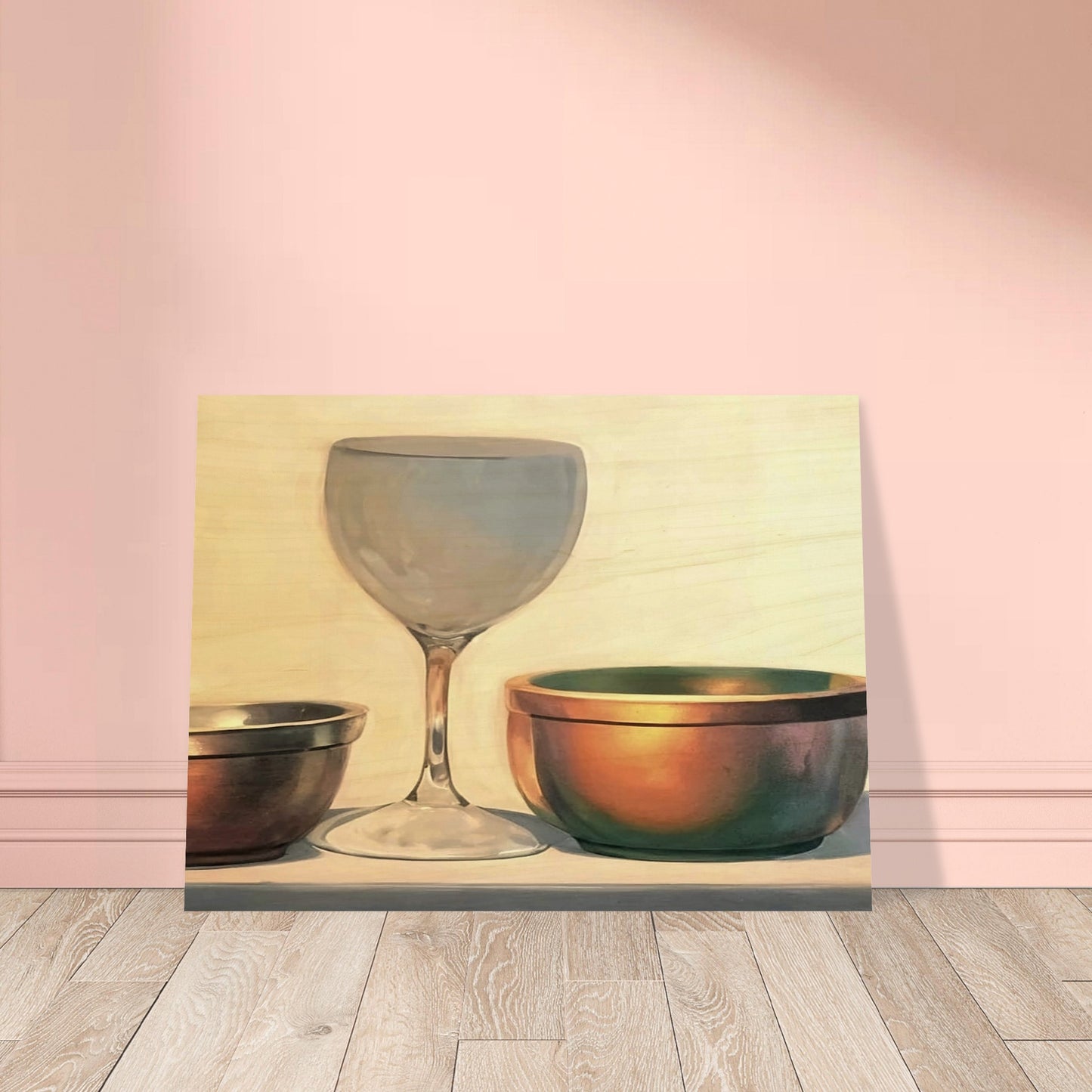 A glass chalice and two metallic bowls arranged in soft light, highlighting their reflective surfaces in a subtle, elegant composition.