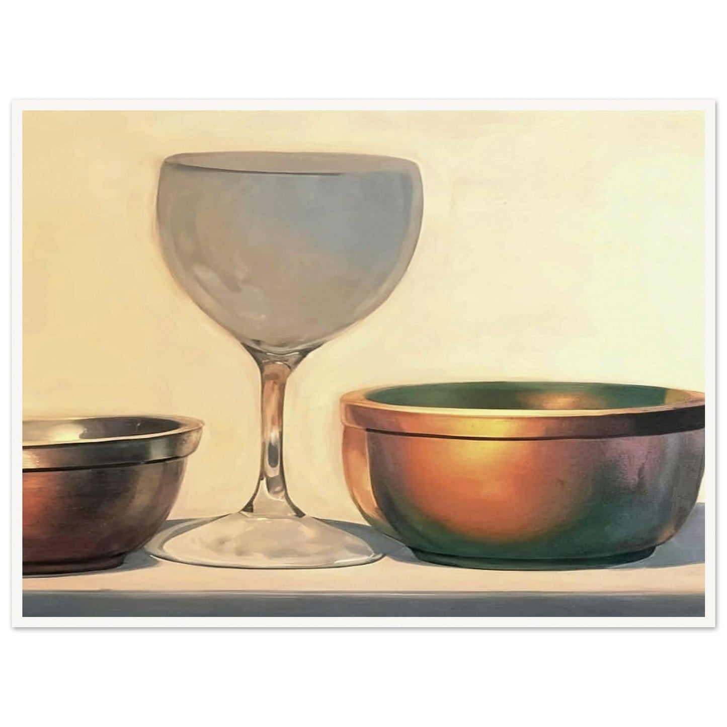 A glass chalice and two metallic bowls arranged in soft light, highlighting their reflective surfaces in a subtle, elegant composition.