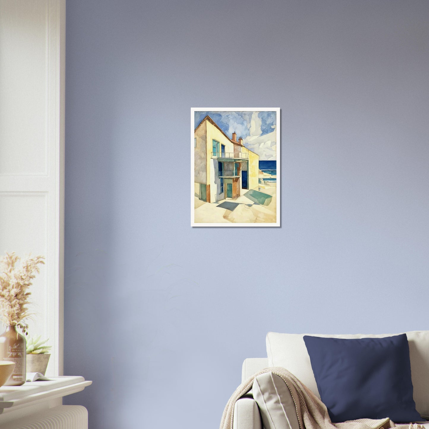 A bright seaside house casts long shadows under the afternoon sun, with a calm ocean and blue skies in the background.