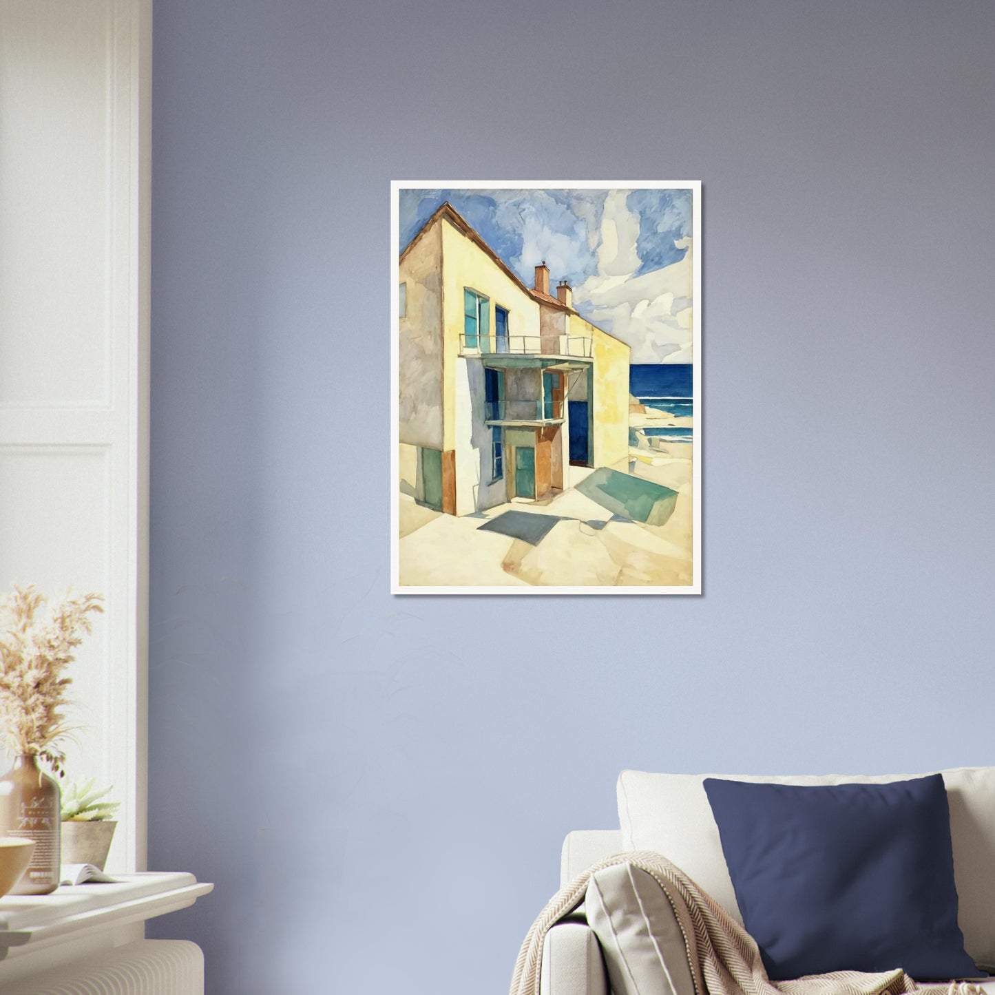 A bright seaside house casts long shadows under the afternoon sun, with a calm ocean and blue skies in the background.