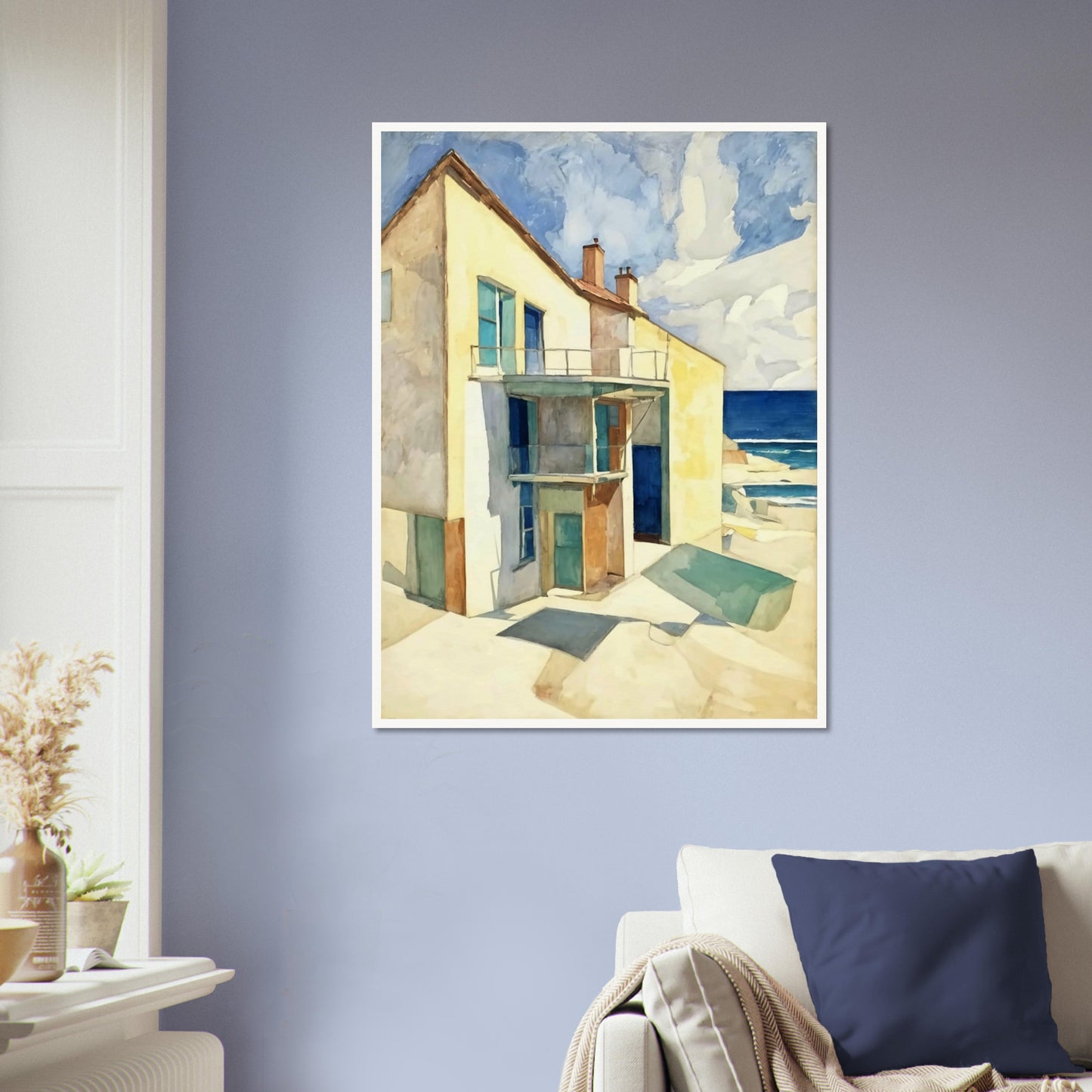 A bright seaside house casts long shadows under the afternoon sun, with a calm ocean and blue skies in the background.