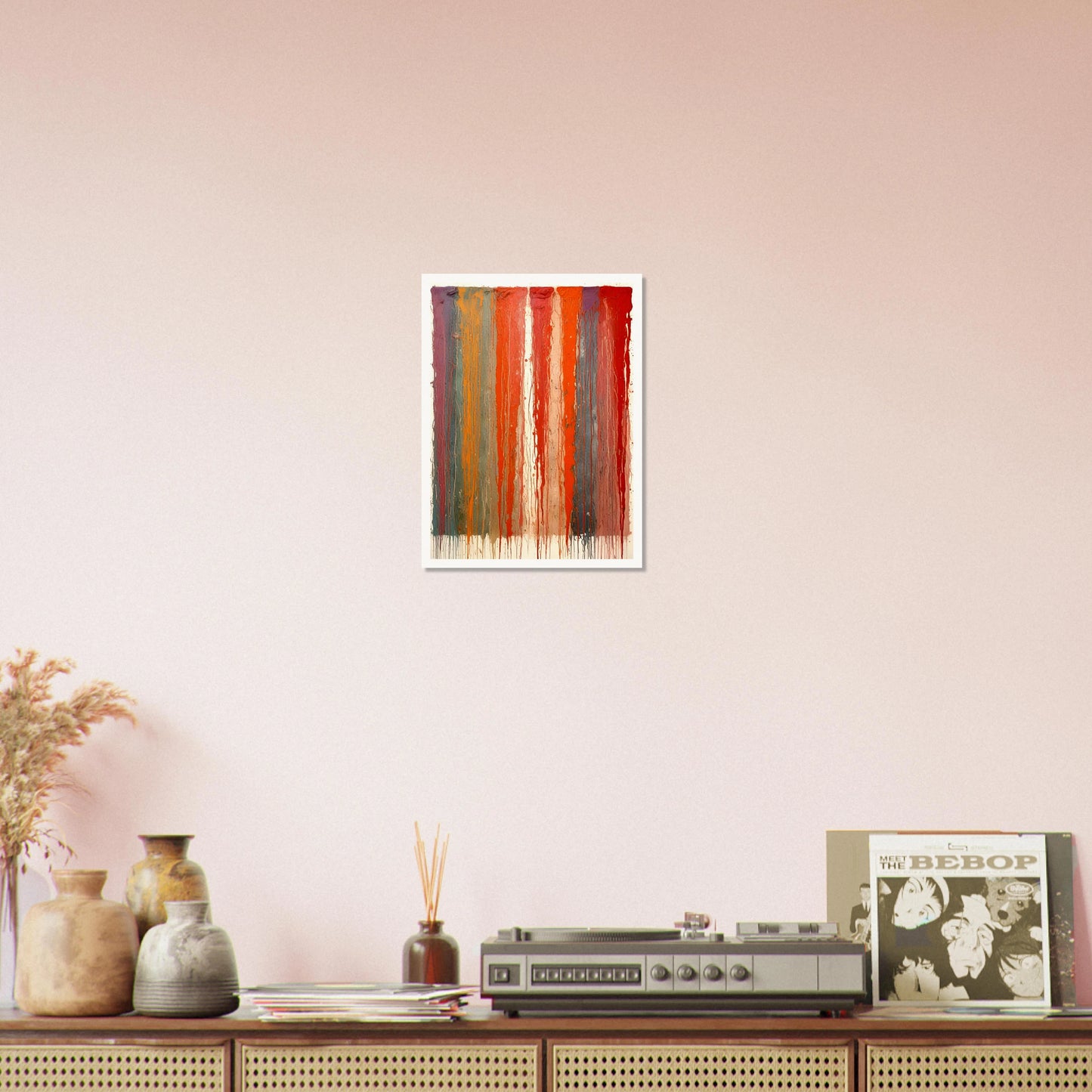 Vertical ribbons of vibrant paint drip down the canvas in layered red, orange, blue, and purple tones against a pale backdrop.