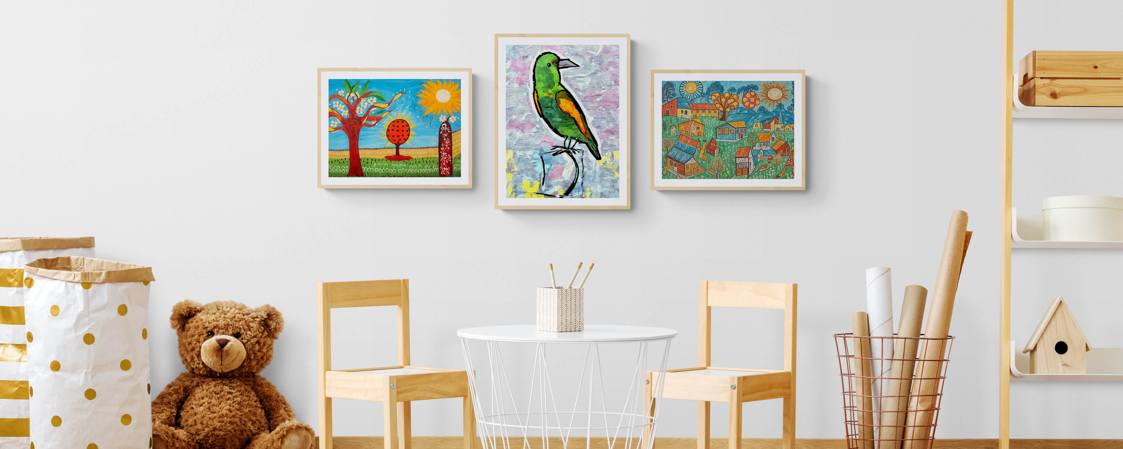 Colorful nursery wall art featuring playful nature scenes and a bird illustration, styled above a children's table and chairs with toys and storage baskets.