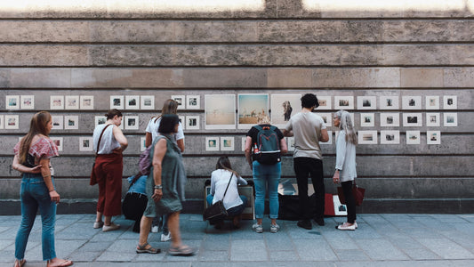 People buying art on the sidewalk