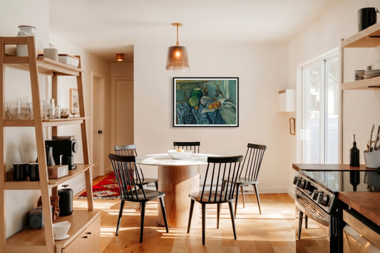 A small dining room with a round table, four chairs, and a still life wall decor idea.