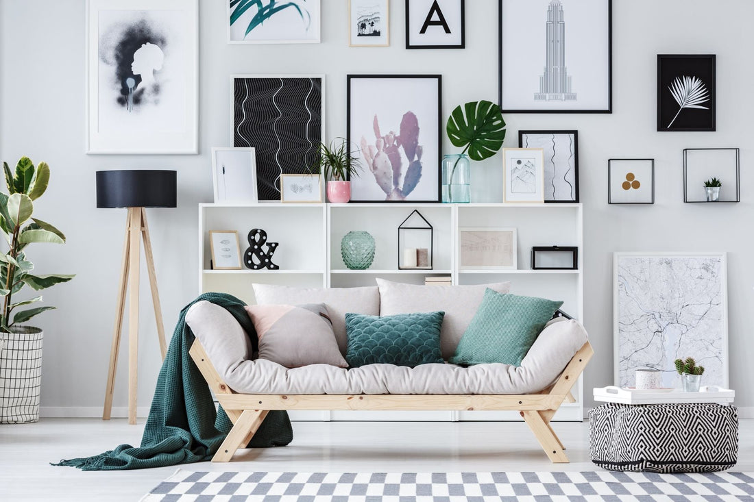 An inviting interior adorned with framed artwork and a pink armchair alongside a green sofa