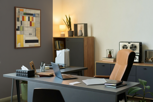 Executive office with desk, laptop, tan chair, shelves, and plants