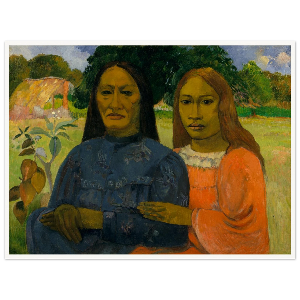 Two Tahitian women sit closely together in colorful dresses against a lush green landscape.