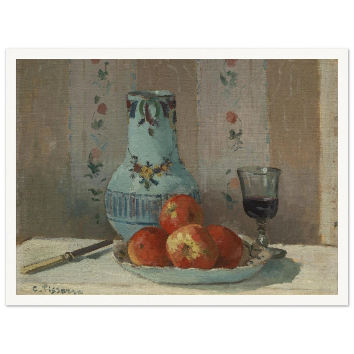 Apples on a plate with a blue pitcher, wine glass, and knife before floral wallpaper.