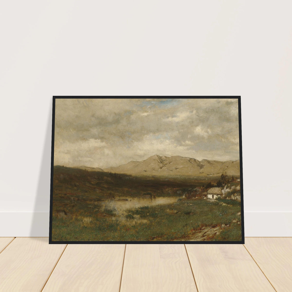 A rural cottage sits below distant mountains beneath a broad, cloudy sky in the Irish countryside.