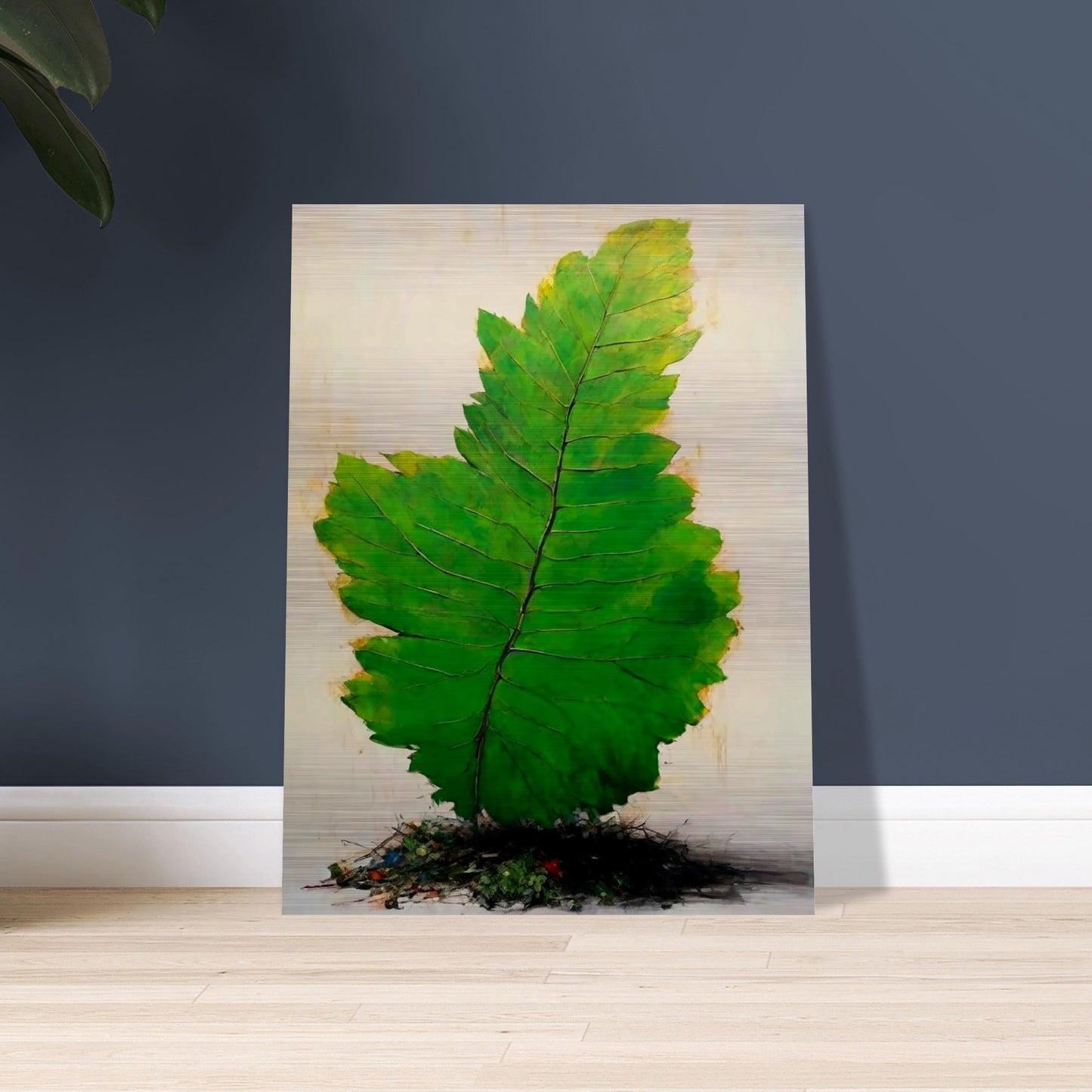 A large, vivid green leaf standing upright against a light background, with intricate veins and subtle texture, emerging from a small mound of organic debris.