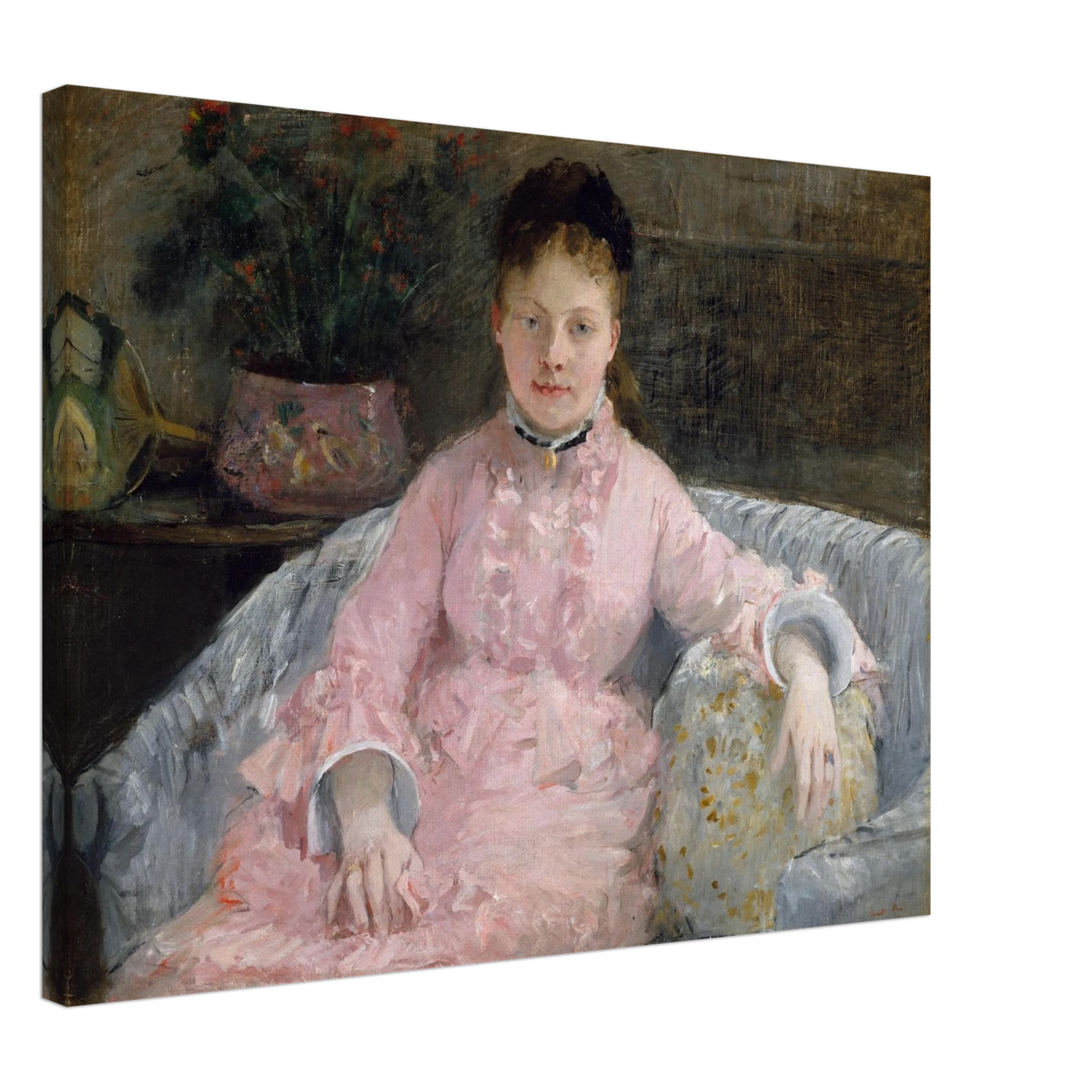Young woman in a pink dress sits on a sofa beside flowers and a patterned pillow
