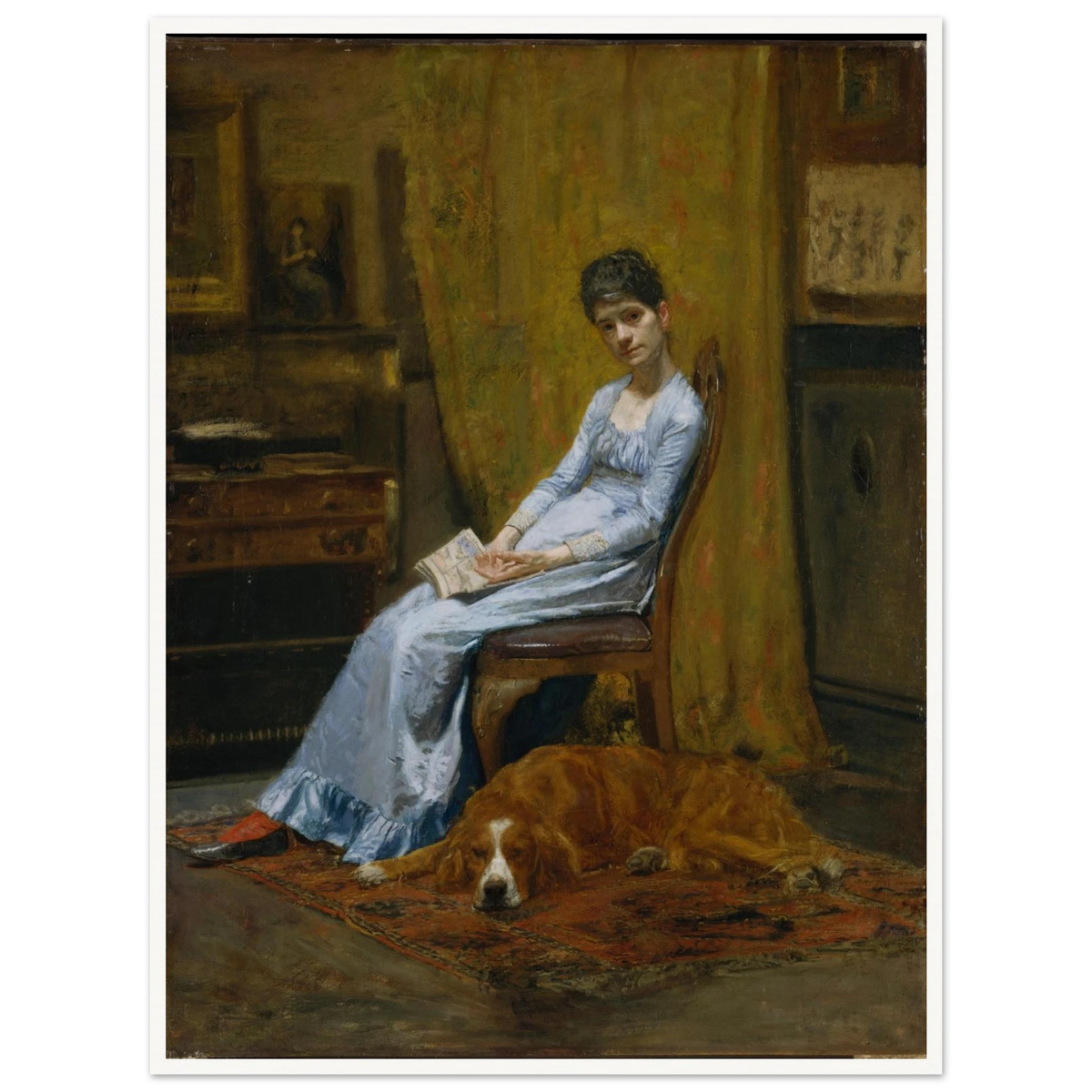 Woman in a blue dress sits with papers beside a sleeping setter dog in a dim studio interior.