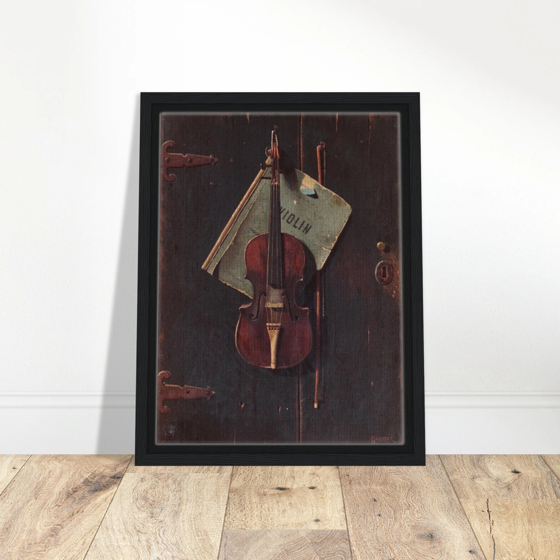 Violin and bow hang against a dark wooden door with a faded paper behind them