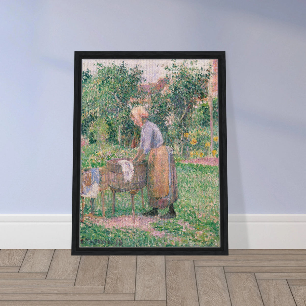 A Pointillist painting of a washerwoman hard at work, scrubbing linens and clothing in one barrel and rinsing them in another. 