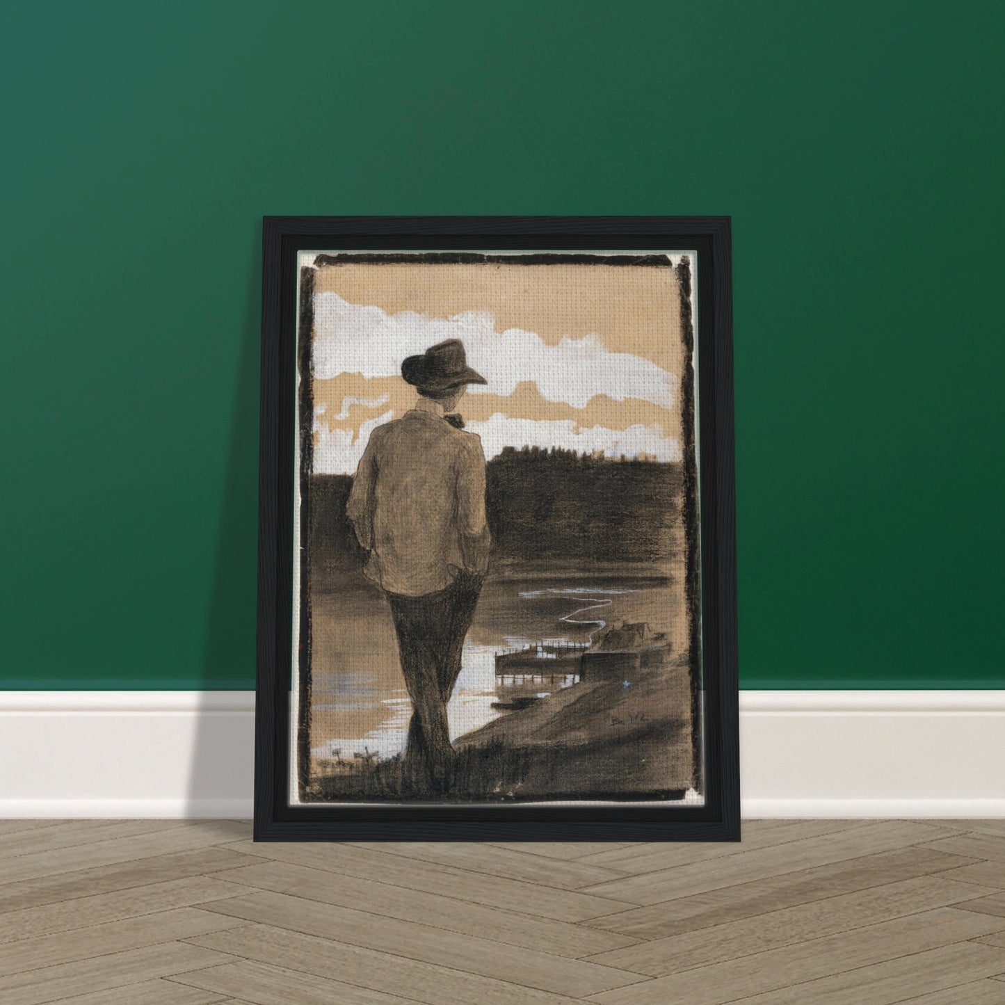 Young man in a hat stands by a riverbank, looking toward clouds and distant water