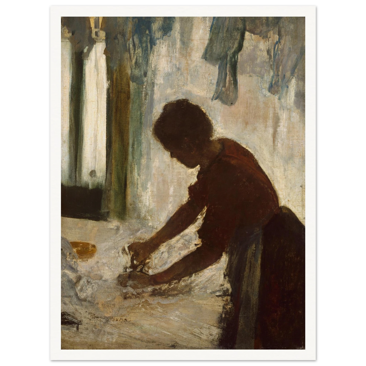 A woman leans over a table ironing white fabric, silhouetted against a softly lit laundry interior.