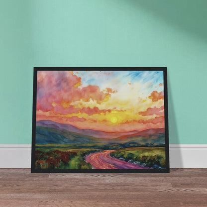 Vibrant watercolor landscape of a winding road through rolling hills beneath a glowing sunset sky filled with pink, gold, and blue clouds.