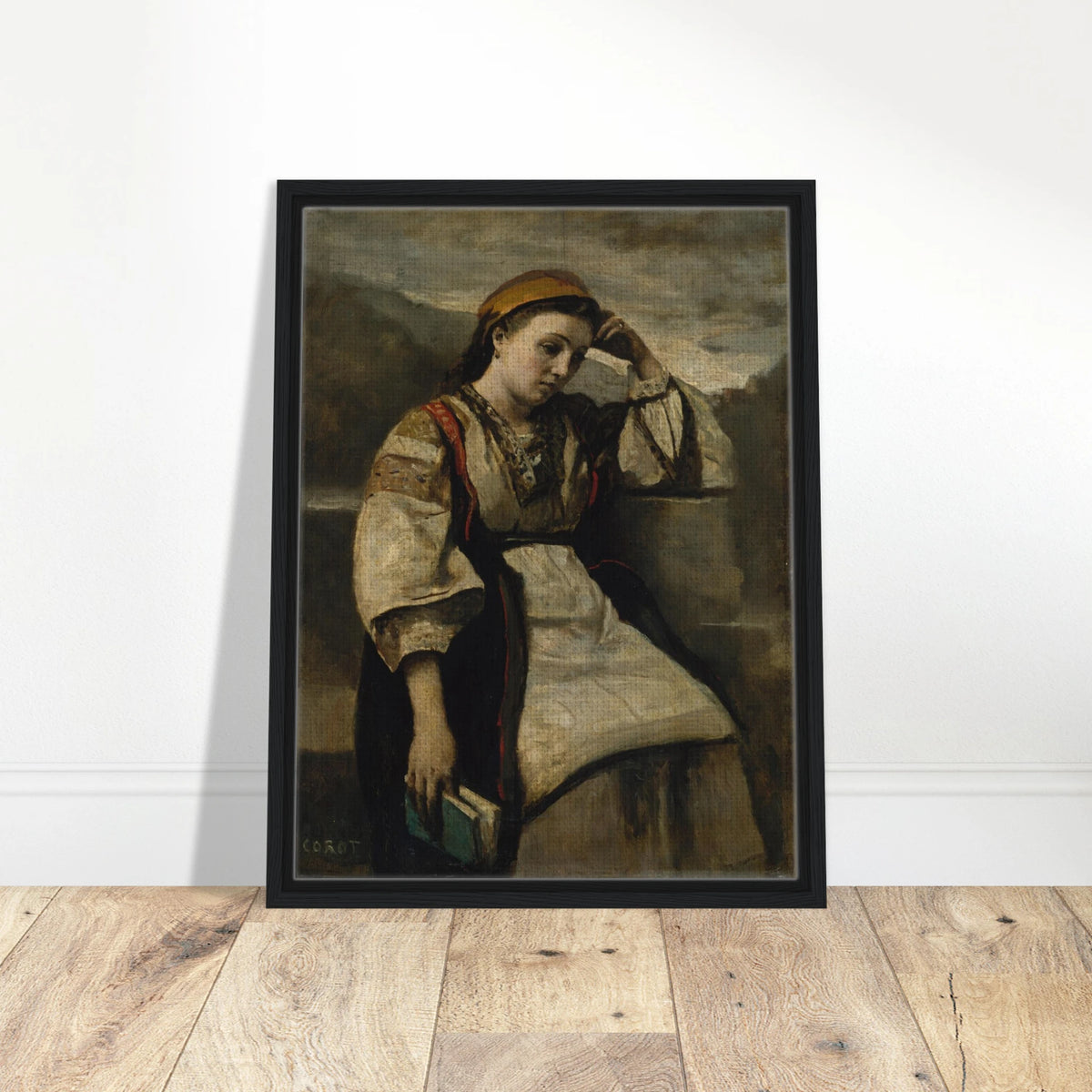 A seated woman in traditional dress rests her head on her hand while holding a book.