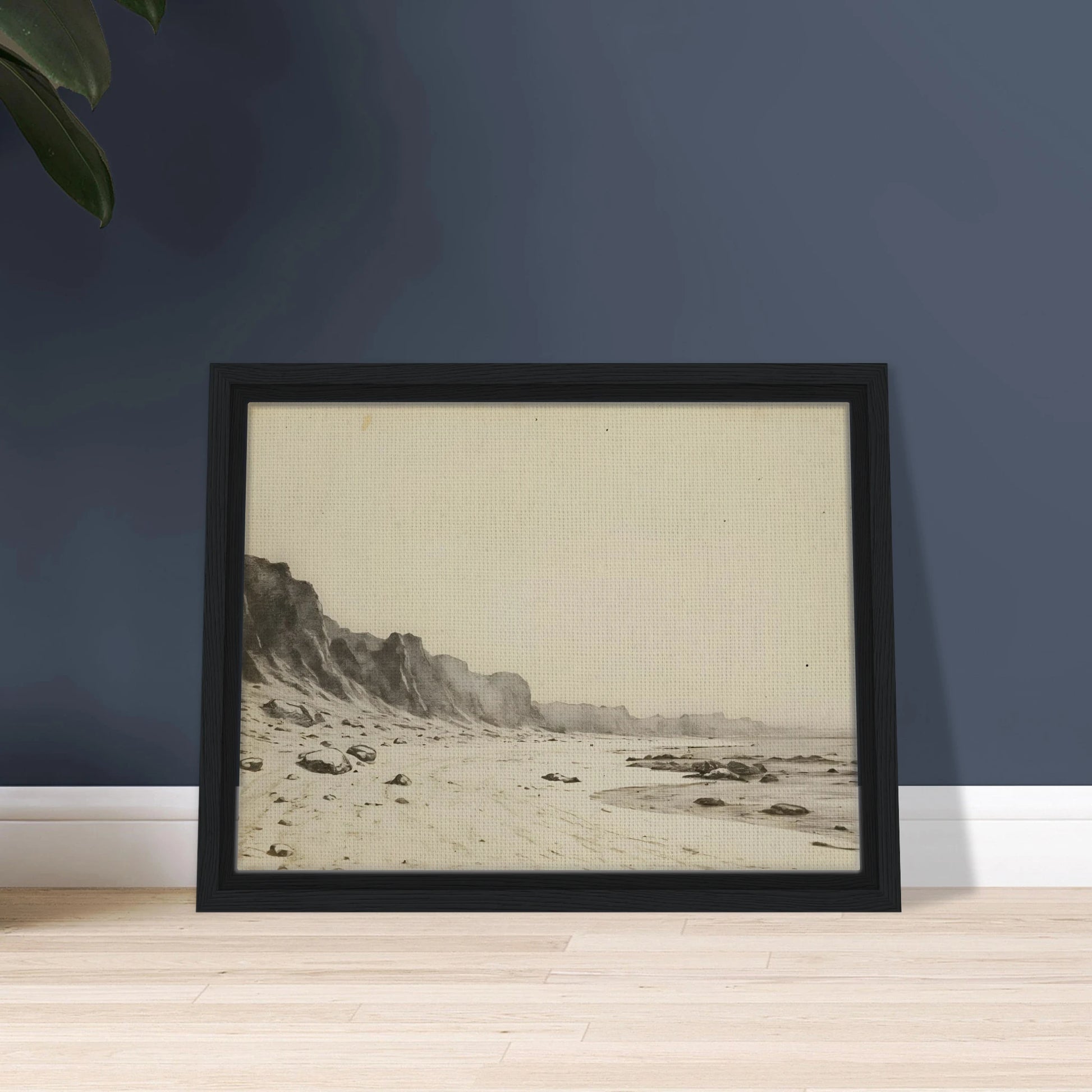 Minimal coastal landscape with pale sandy shore, rugged cliffs, scattered stones, and calm sea rendered in soft monochrome tones.