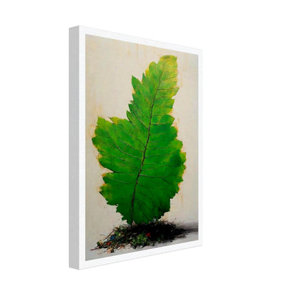 A large, vivid green leaf standing upright against a light background, with intricate veins and subtle texture, emerging from a small mound of organic debris.