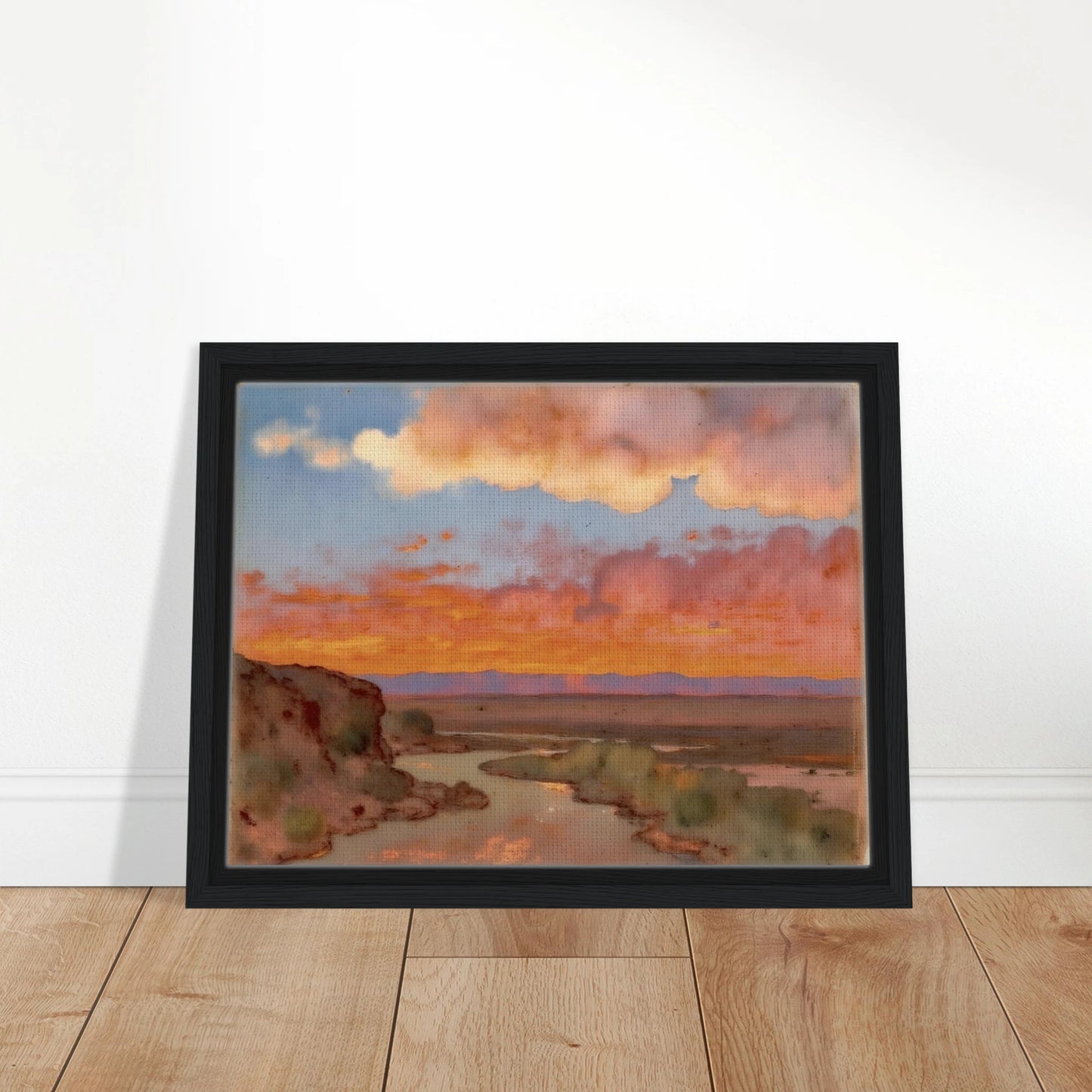 Soft desert river winding beneath glowing orange and pink sunset clouds, with distant plains and muted cliffs in a serene landscape.