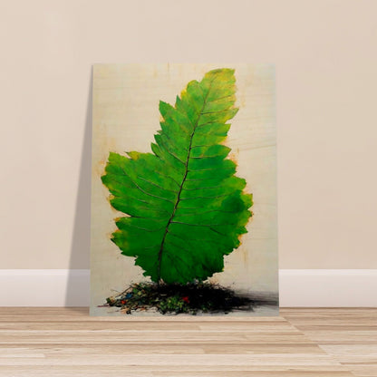 A large, vivid green leaf standing upright against a light background, with intricate veins and subtle texture, emerging from a small mound of organic debris.