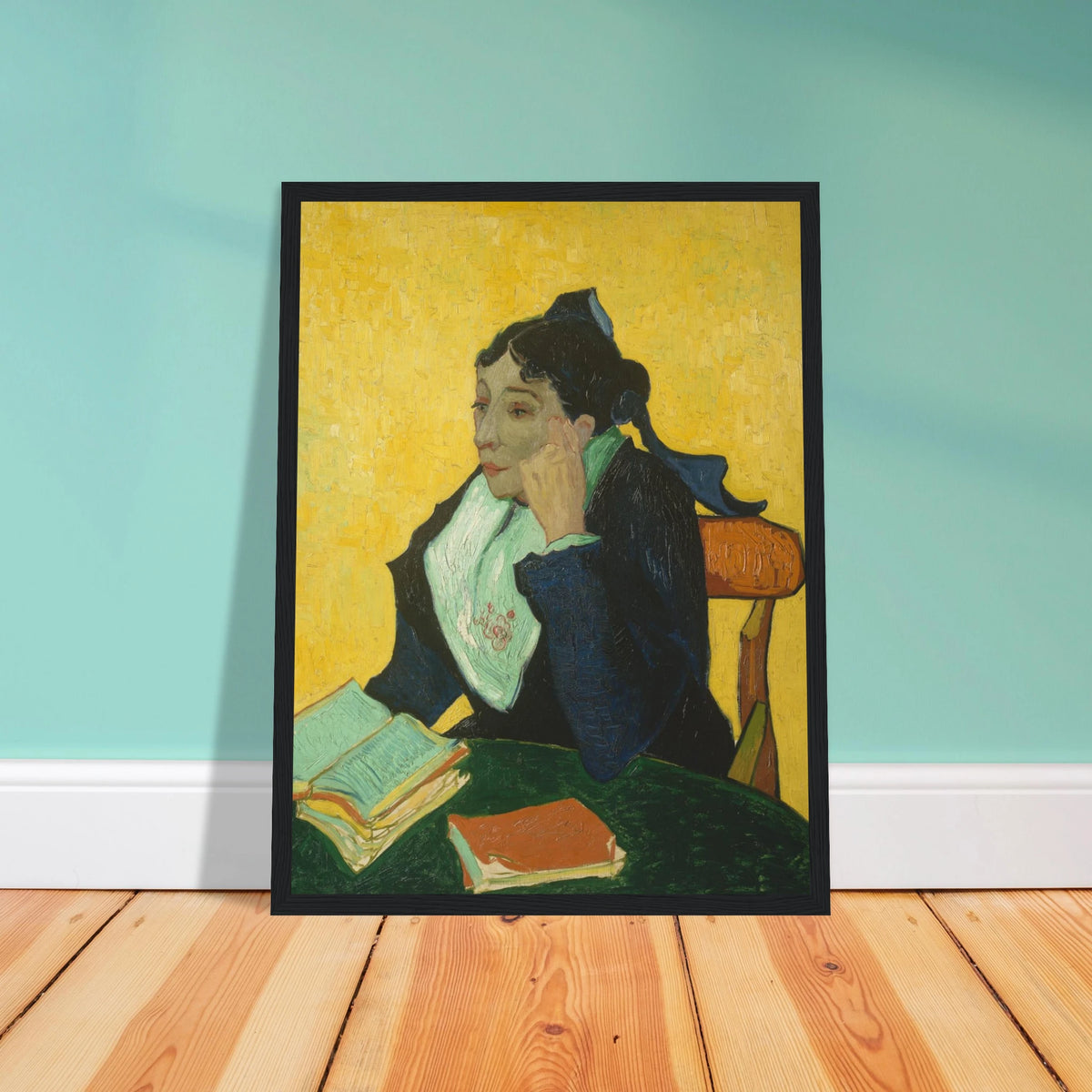 Woman in black and green sits at a table with open books against a vivid yellow background.