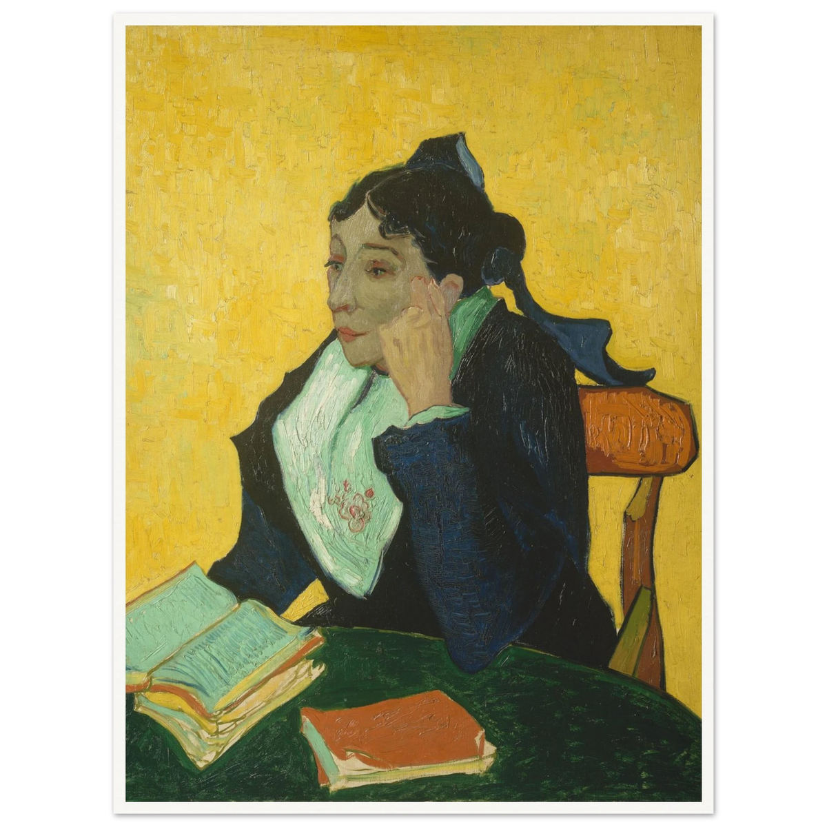 Woman in black and green sits at a table with open books against a vivid yellow background.