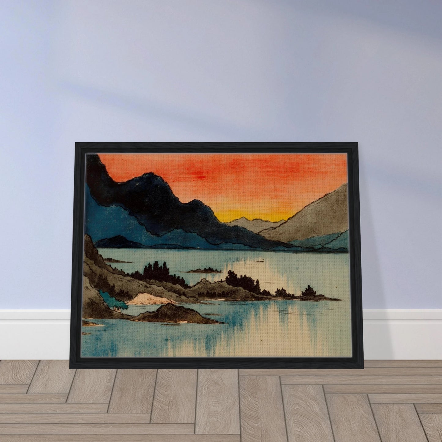 Layered mountain silhouettes meet a glowing red and yellow sunset above calm blue lake waters in a serene scenic view.