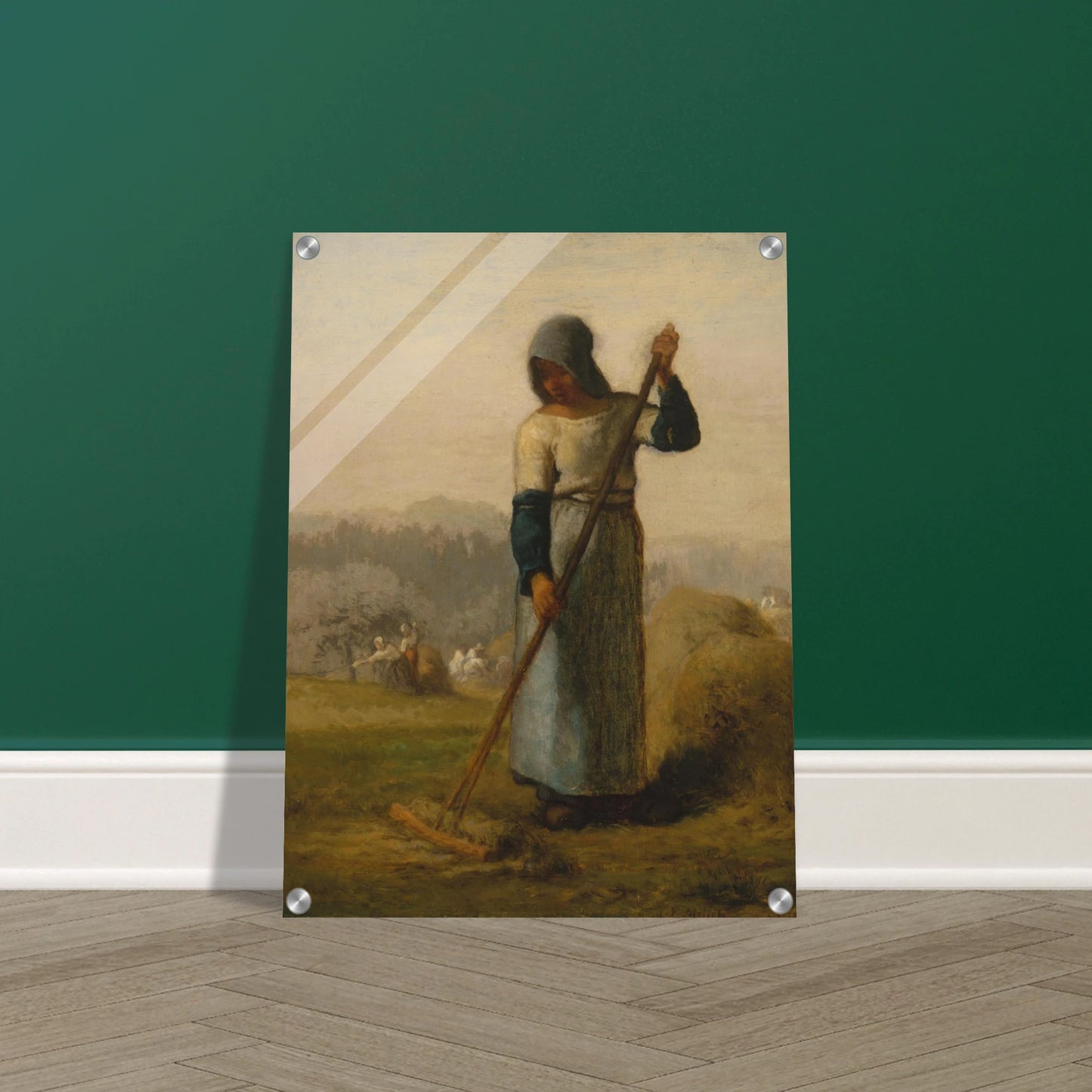A peasant woman holds a wooden rake beside a haystack as farm workers gather hay in a distant field.