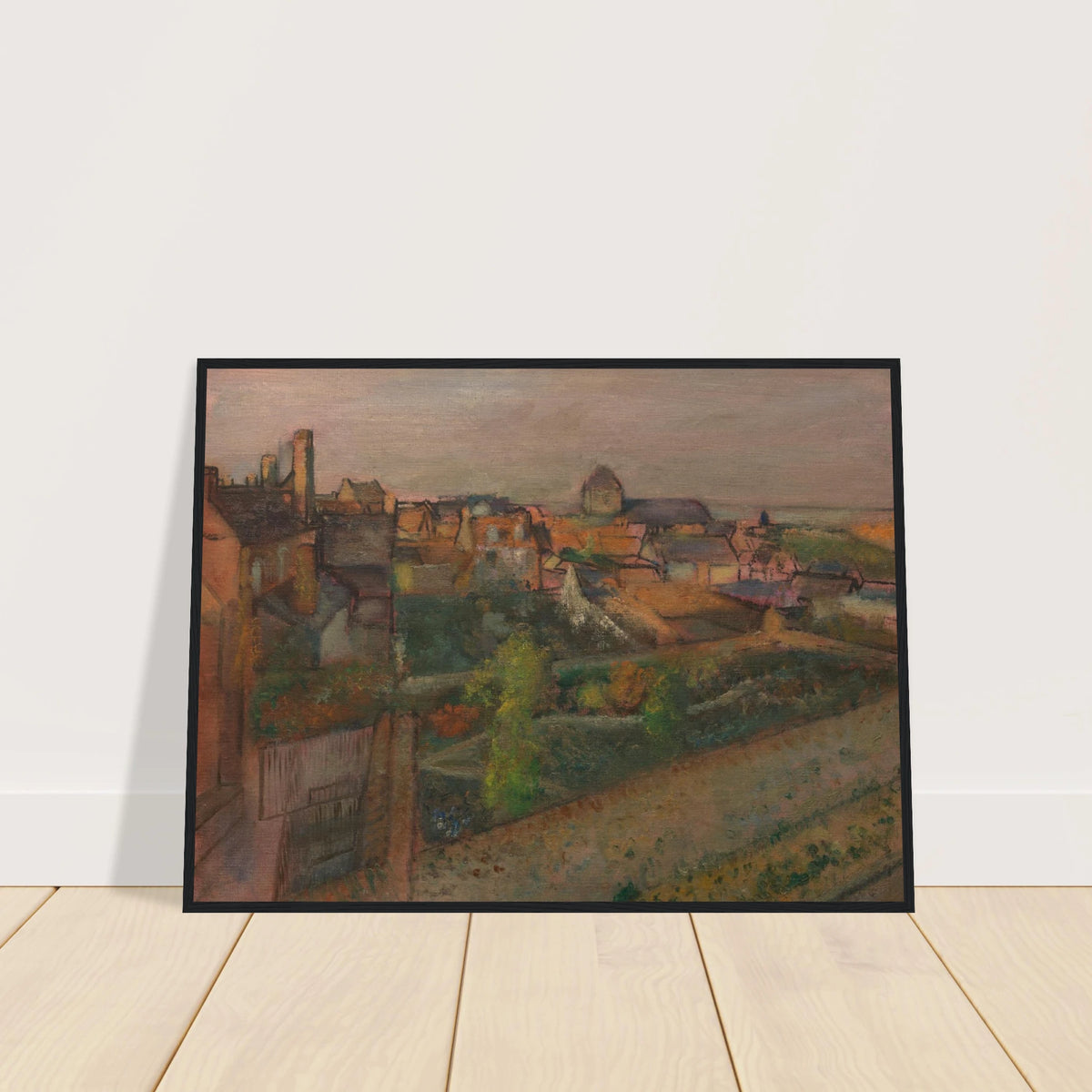 A high view of Saint-Valéry-sur-Somme with rooftops, gardens, and distant water under a pale sky.