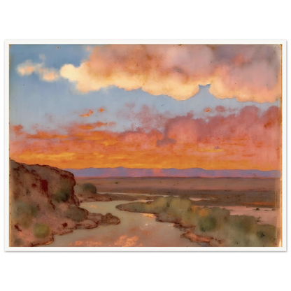 Soft desert river winding beneath glowing orange and pink sunset clouds, with distant plains and muted cliffs in a serene landscape.