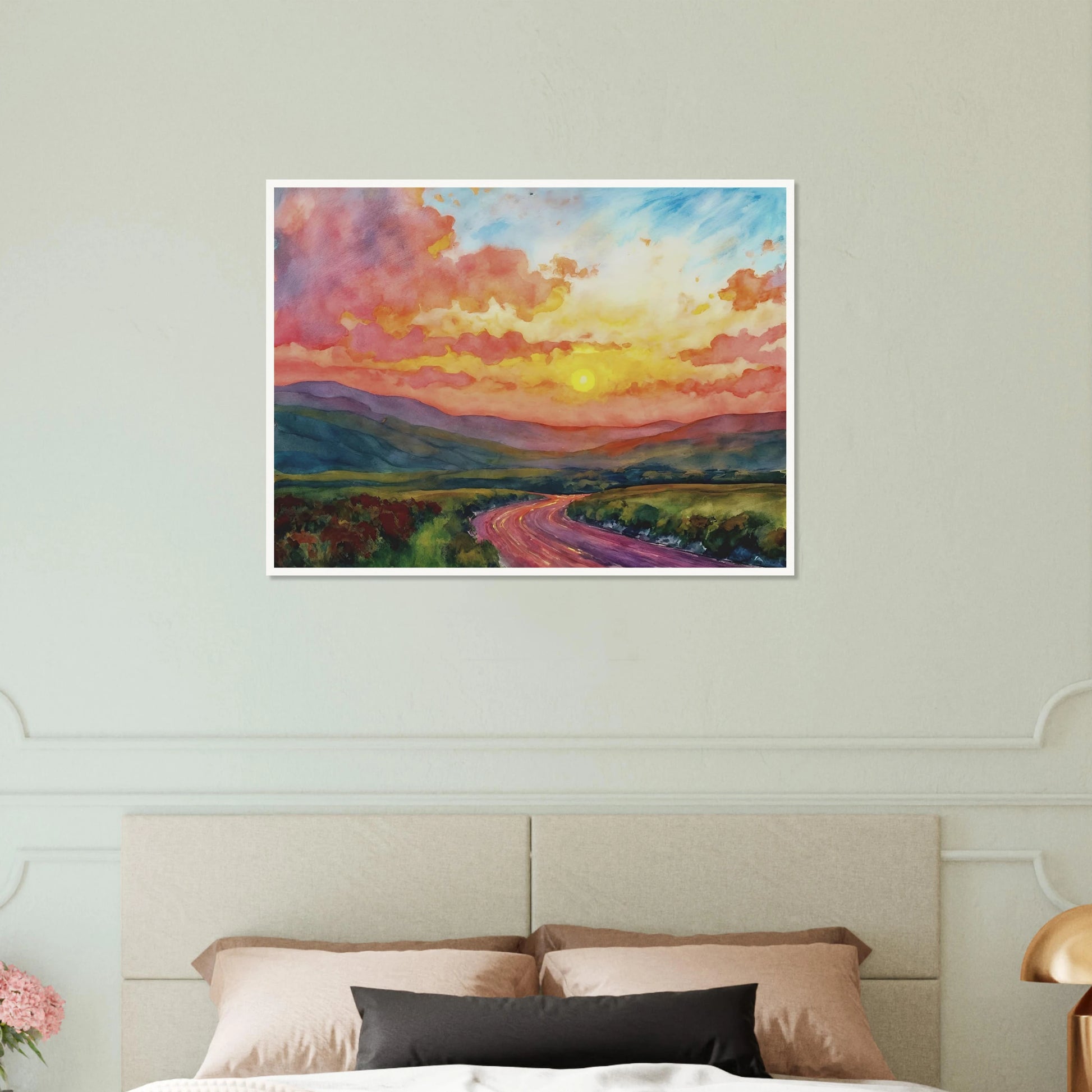Vibrant watercolor landscape of a winding road through rolling hills beneath a glowing sunset sky filled with pink, gold, and blue clouds.