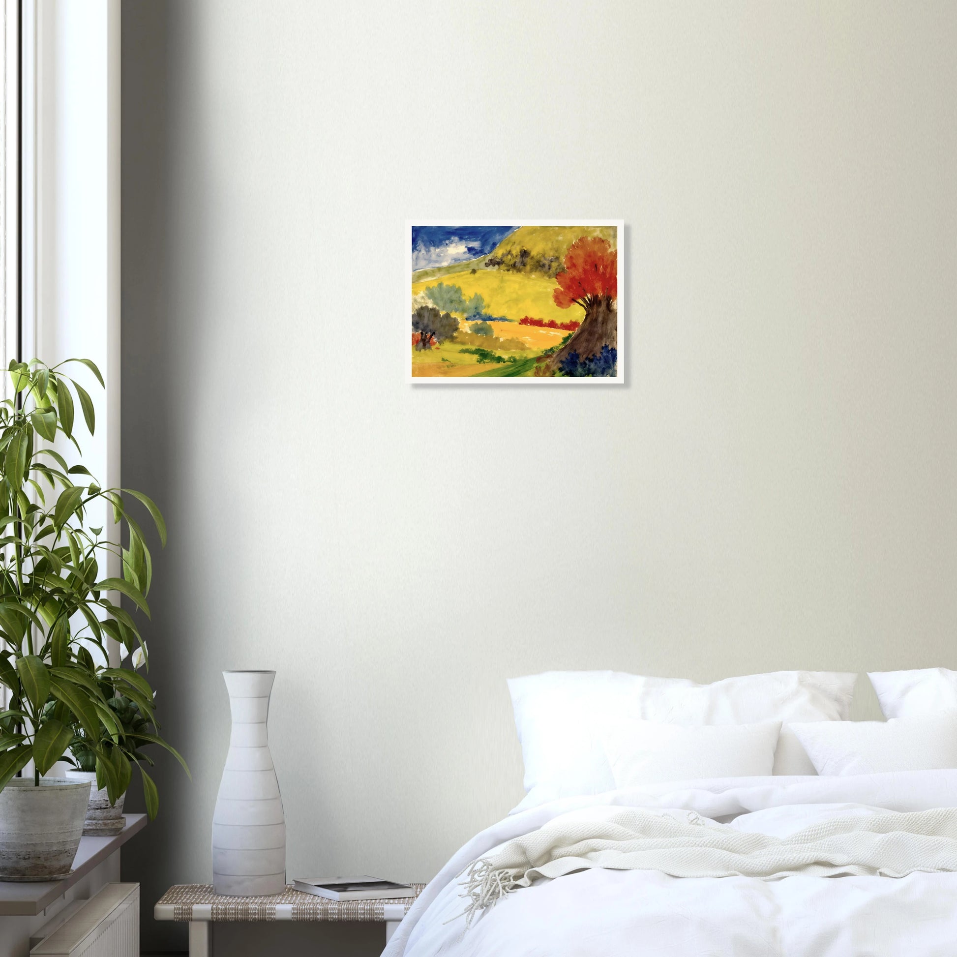 Red tree rises beside golden hills, green fields, and a deep blue sky in a bright countryside scene.