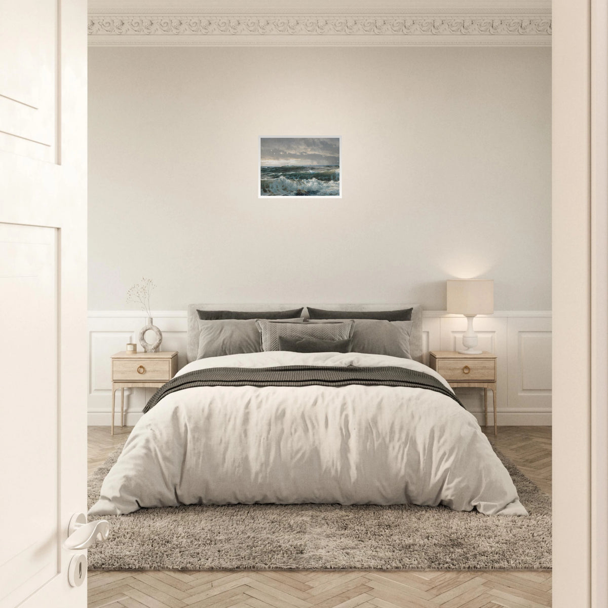Stormy waves crash over dark rocks beneath heavy gray clouds in a dramatic seascape.
