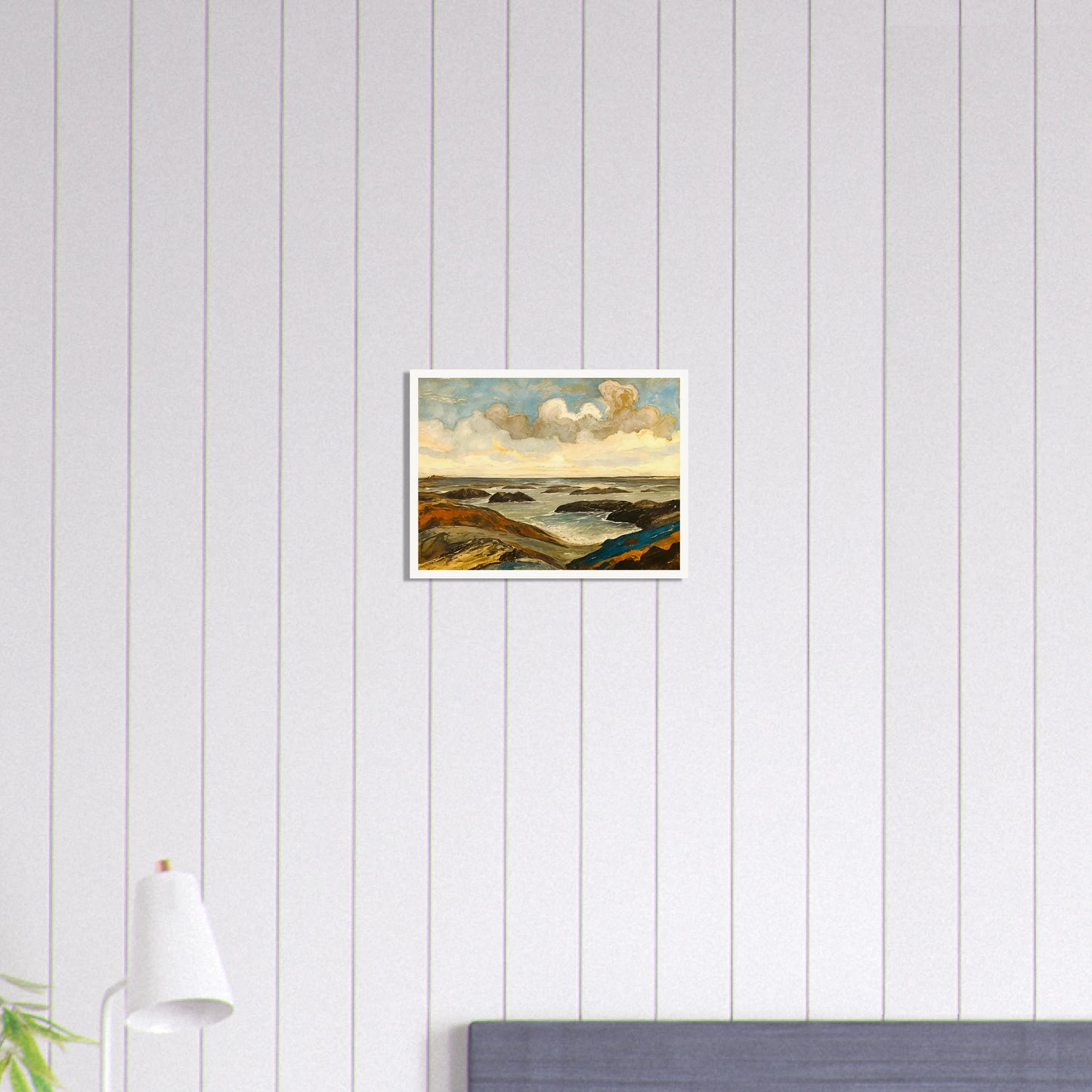 Rocky seashore with dark stones and rolling waves beneath a dramatic sky of shifting clouds and golden sunlight.