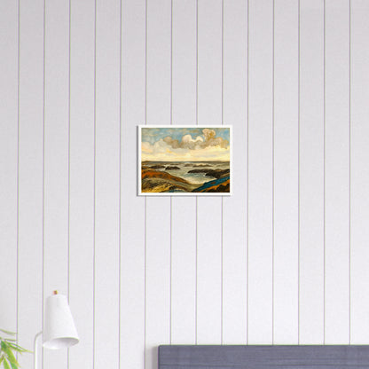 Rocky seashore with dark stones and rolling waves beneath a dramatic sky of shifting clouds and golden sunlight.