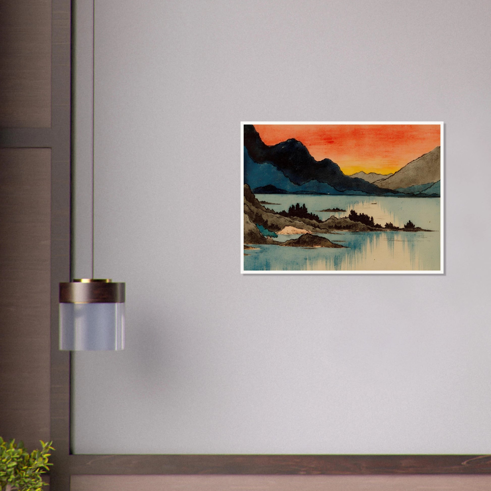 Layered mountain silhouettes meet a glowing red and yellow sunset above calm blue lake waters in a serene scenic view.