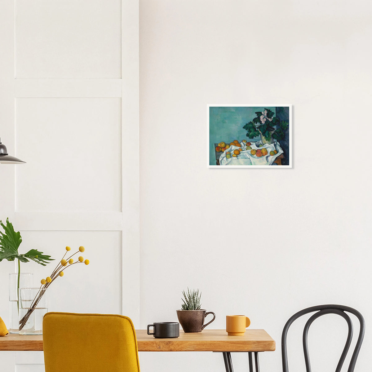 Apples on a white cloth beside a potted primrose plant against a blue-green wall.
