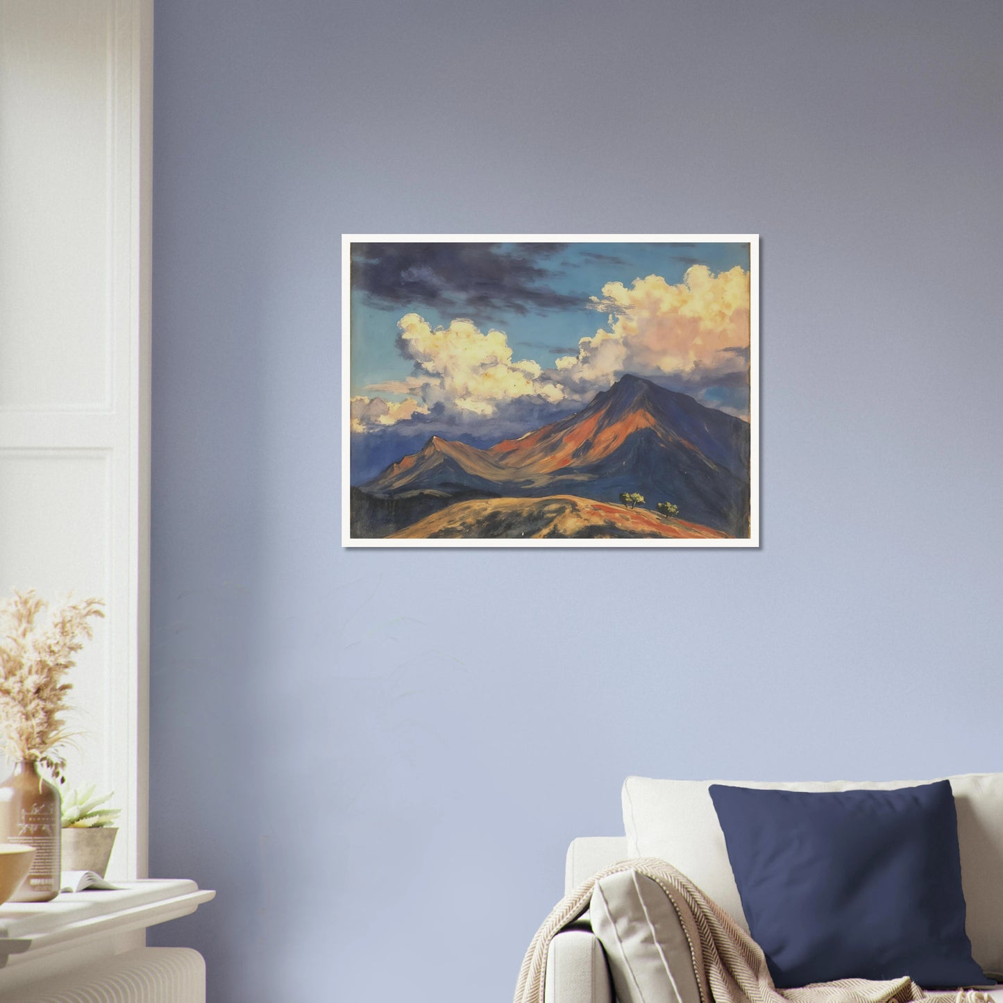 Sunlit mountain peaks glow beneath towering cream clouds and deep blue skies, with warm ridges stretching across an open landscape.