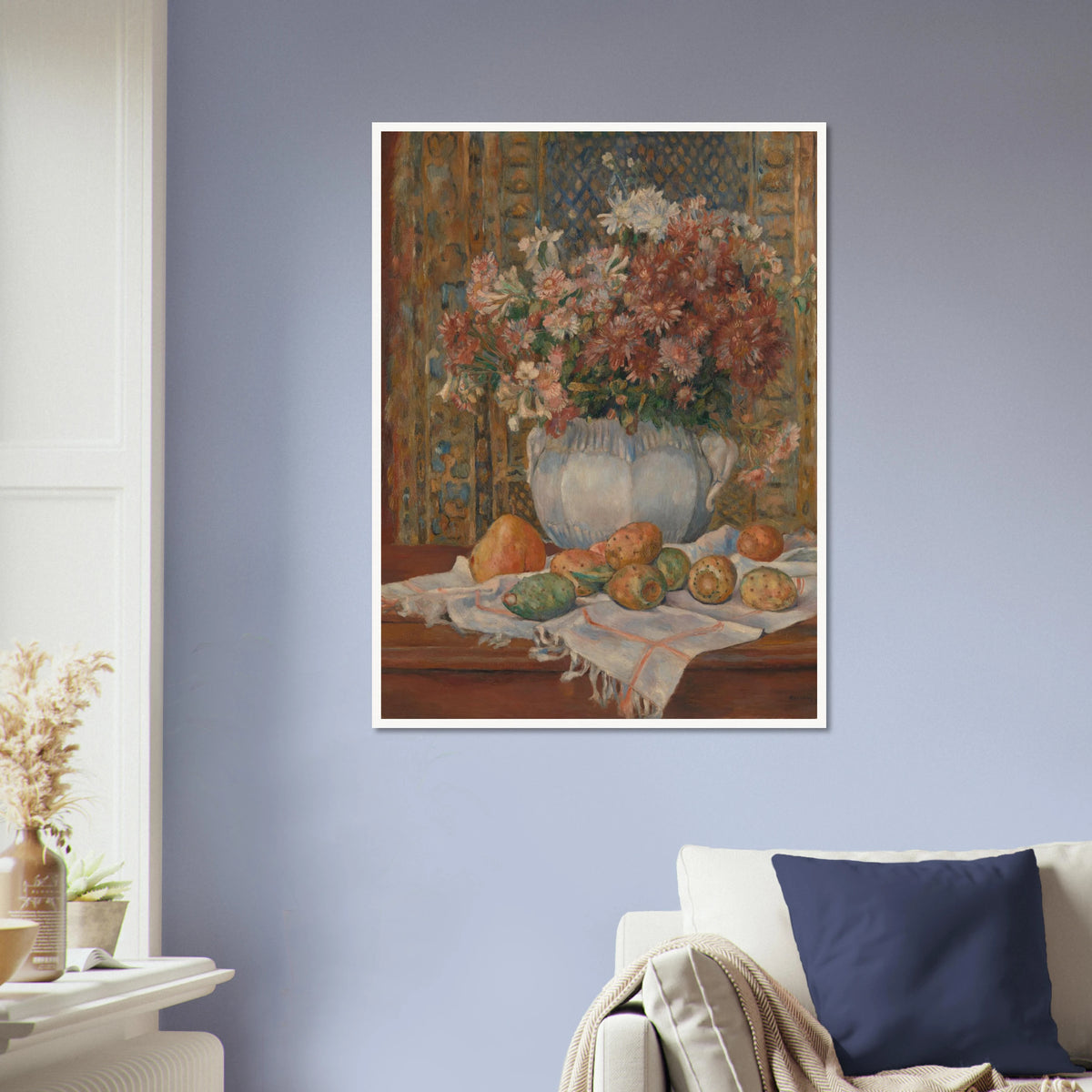 Autumn flowers in a blue vase with prickly pears and cloth on a table before a patterned screen.