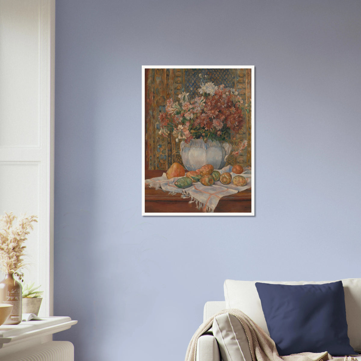 Autumn flowers in a blue vase with prickly pears and cloth on a table before a patterned screen.