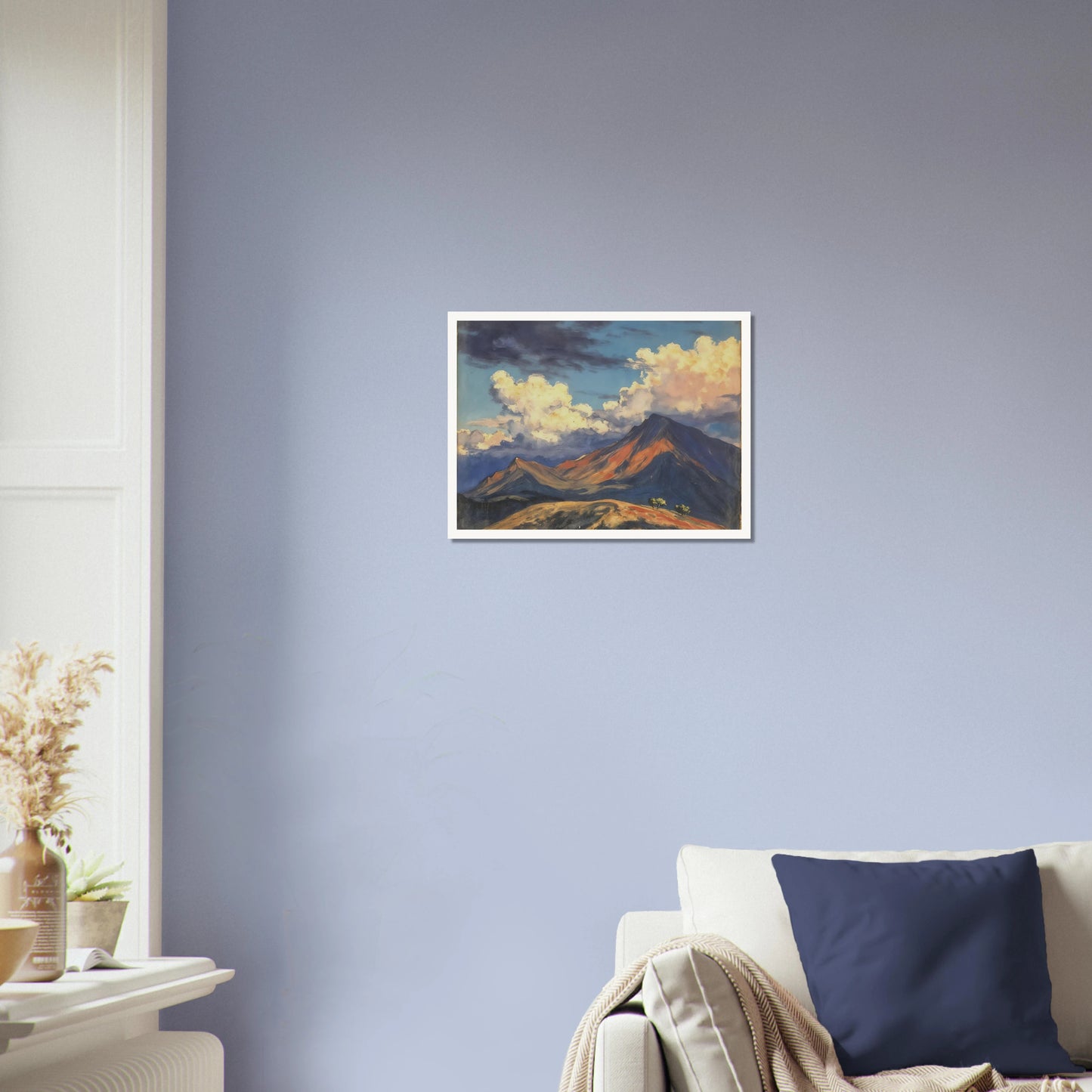 Sunlit mountain peaks glow beneath towering cream clouds and deep blue skies, with warm ridges stretching across an open landscape.