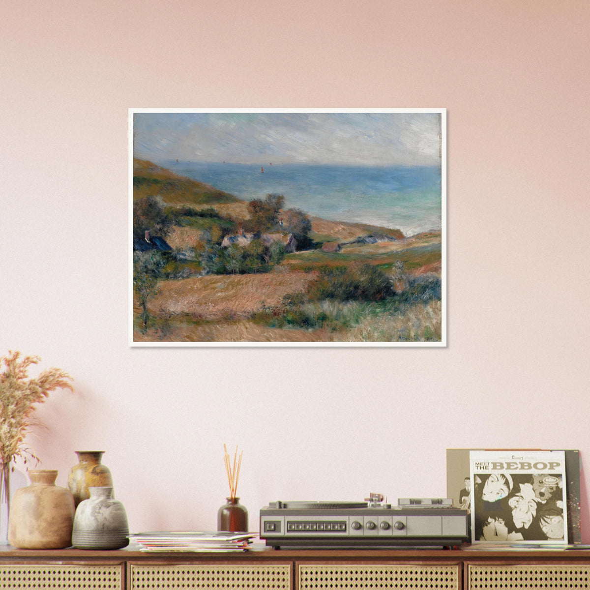 A Normandy coast with grassy fields, cottages, and a calm blue sea beneath a pale sky.