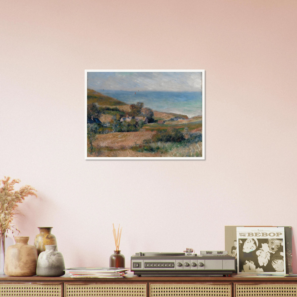 A Normandy coast with grassy fields, cottages, and a calm blue sea beneath a pale sky.